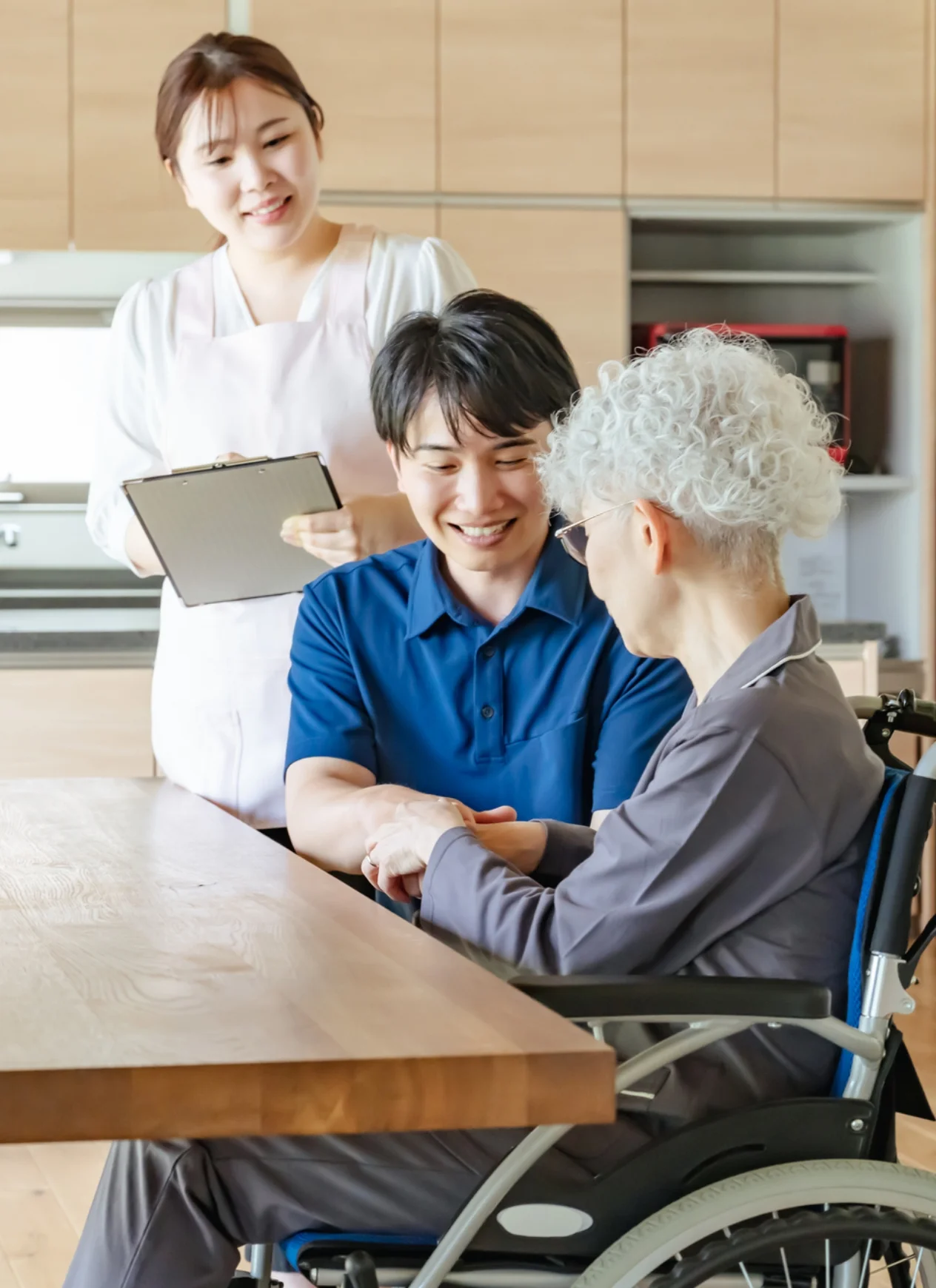 ご自宅で過ごす車いすの方とご家族、看護師
